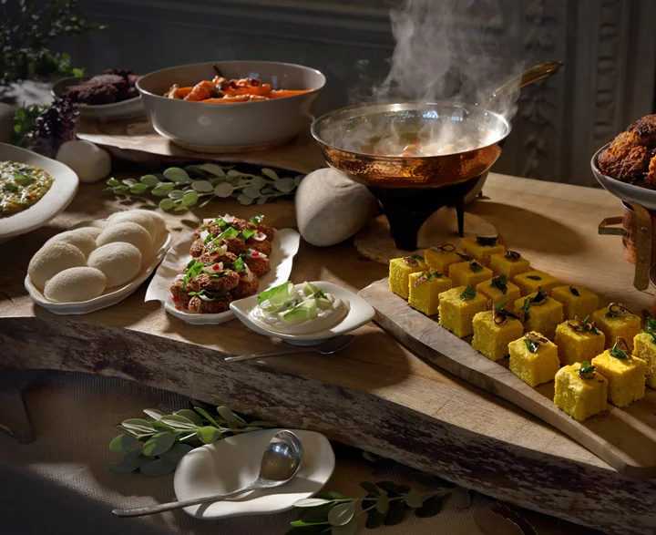 Food styled along a wooden table, steaming and freshly prepared.
