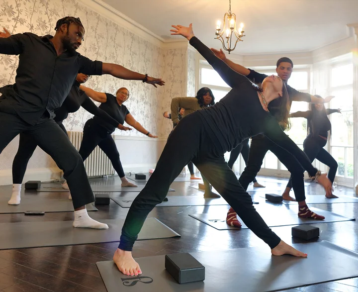 Yoga class stretching together on yoga mats.